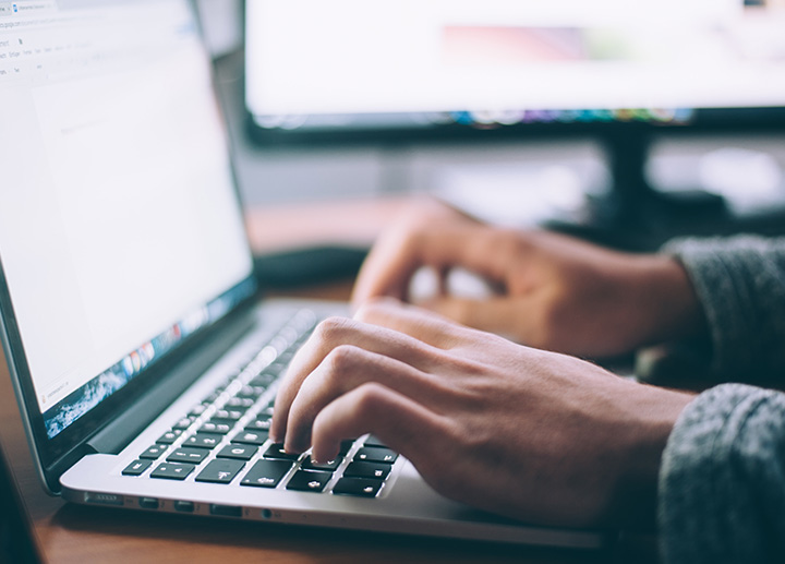 Hands typing on a keyboard